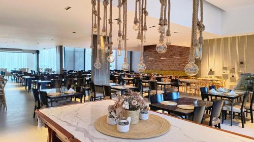 a dining room with tables and chairs and chandeliers at HDA Hotel & Spa in Termas de Río Hondo