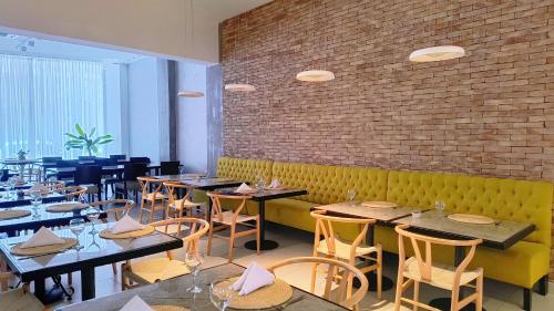 a restaurant with tables and chairs and a brick wall at HDA Hotel & Spa in Termas de Río Hondo