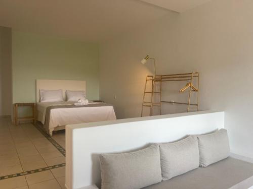 1 dormitorio con cama y mesa con almohadas en Lipsi Blue Hotel en Lipsoi