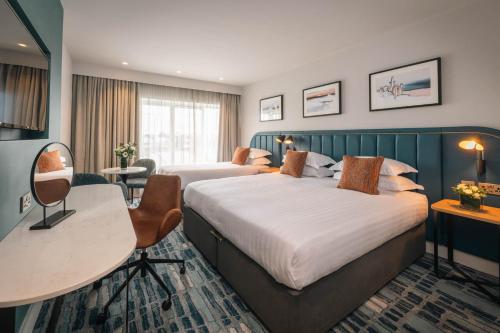 Habitación de hotel con 2 camas y escritorio en Waterford Viking Hotel en Waterford