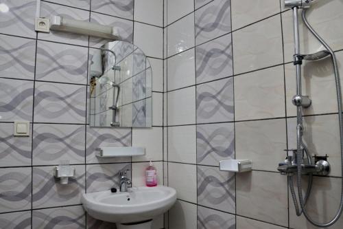 La salle de bains est pourvue d'un lavabo et d'une douche. dans l'établissement J&B Home, à Kribi