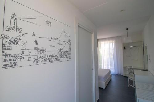 a bedroom with a drawing on the wall at Hotel Arte Mare in San Vito lo Capo