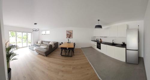 cocina y sala de estar con sofá y mesa en Moderne Wohnung am Rhein, en Coblenza