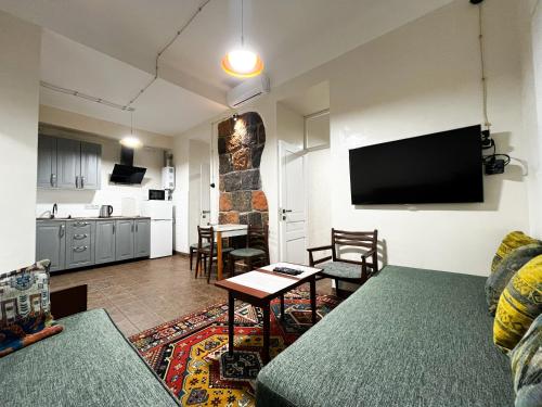 a living room with a couch and a table and a kitchen at Apartments Pushkin Street in Yerevan