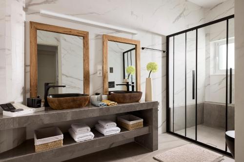 a bathroom with two sinks and two mirrors at Luxury White House - Villa & Weddings - Family Villa Near the Sea to the Famous Zorbas Beach in Stavros