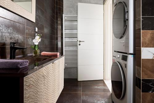 a bathroom with a sink and a washing machine at Luxury White House - Villa & Weddings - Family Villa Near the Sea to the Famous Zorbas Beach in Stavros