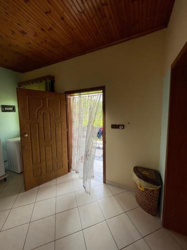 Habitación con puerta, ventana y suelo de baldosa. en Villa Mance, en Berat