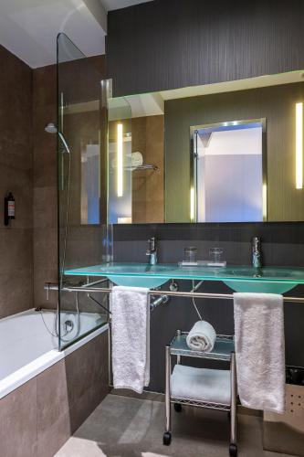 a bathroom with a sink and a tub and a mirror at Porcel Torneo in Seville
