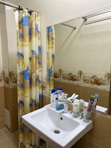 a bathroom with a sink and a shower curtain at Stariy Marokand in Samarkand