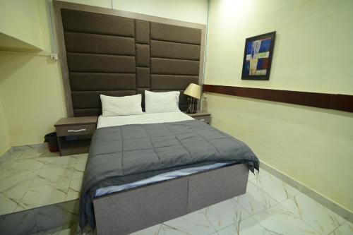 a bedroom with a large bed with a large headboard at SEAVIEW COTTAGE in Karachi