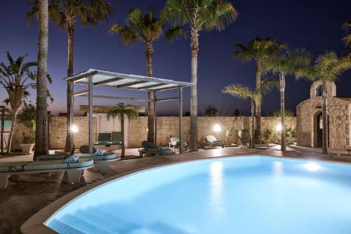 a swimming pool with palm trees and a gazebo at Luxury White House - Villa & Weddings - Family Villa Near the Sea to the Famous Zorbas Beach in Stavros