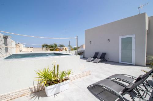 a patio with chairs and a swimming pool on a house at Hotel Arte Mare in San Vito lo Capo