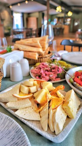 a table with a plate of cheese and other foods at Burki Castle & Cellar in Kvareli
