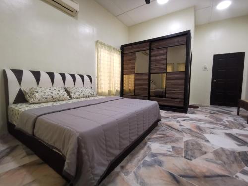 a bedroom with a large bed and a mirror at Kejora Guest House in Kuantan