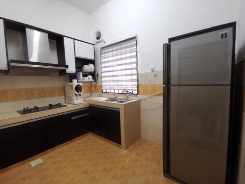 a kitchen with a stainless steel refrigerator and a sink at Kejora Guest House in Kuantan