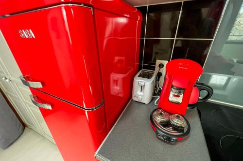 un réfrigérateur rouge avec une cafetière sur un comptoir dans l'établissement Coeur de fête, Quartier des Artistes, à Avignon