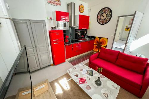 un salon avec un canapé rouge et une table dans l'établissement Coeur de fête, Quartier des Artistes, à Avignon
