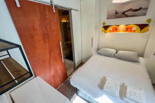 Cette petite chambre comprend un lit et une porte. dans l'établissement Coeur de fête, Quartier des Artistes, à Avignon