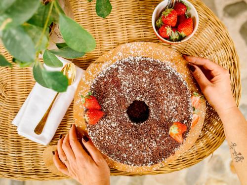 a person holding a cake with strawberries on a table at Amy B&B casetta di charme in Vercelli