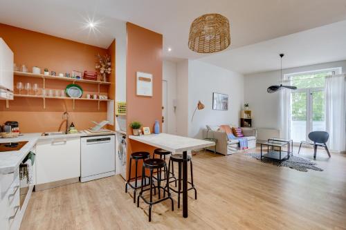une cuisine et un salon avec une table et des chaises dans l'établissement Pause Pastel - Charmant & lumineux T3, à Toulouse