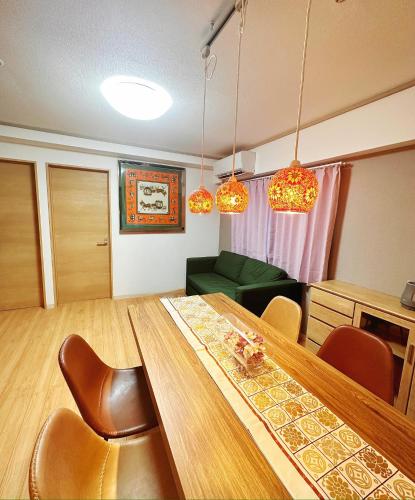 a dining room with a table and chairs and lights at 長期滞在 HYGGE HOUSE 駐車無料 JR北柏駅徒歩2分 フルキッチン 洗濯乾燥機 高速Wi-Fi アメニティ完備 上野30分 成田or羽田空港60分 in Kashiwa
