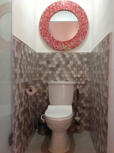 La salle de bains est pourvue de toilettes et d'un miroir rouge. dans l'établissement Guesthouse MALAGUETA INN I & II, à Maputo