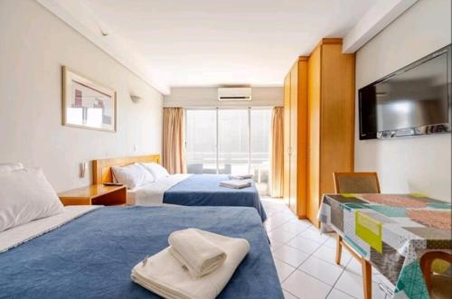 a hotel room with two beds and a flat screen tv at Belo apartamento Perdizes em frente o Allianz Parque com estacionamento in São Paulo