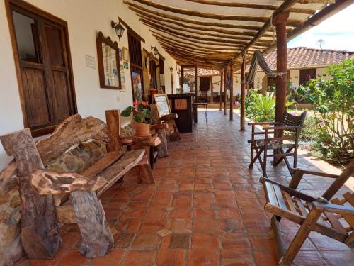 a patio with wooden benches and tables in a building at La Loma Hotel Barichara in Barichara
