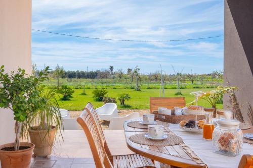 a table and chairs on a patio with a view of a field at Villa Medea in Casarano