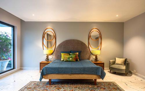 a bedroom with a bed and two mirrors on the wall at Amorzito by Solitaire Stays in Marmagao