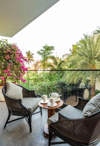 a patio with chairs and a table with cups on it at Amorzito by Solitaire Stays in Marmagao