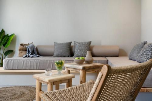 a living room with a couch and two chairs at Amo Golden Suites in Chrysi Ammoudia