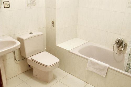een witte badkamer met een toilet en een wastafel bij 5 bedrooms house with city view and terrace at Banos de Valdearados in Baños de Valdearados