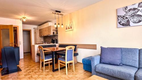 uma sala de estar com uma mesa e um sofá azul em Apartments Bergblick em Sonnenalpe Nassfeld
