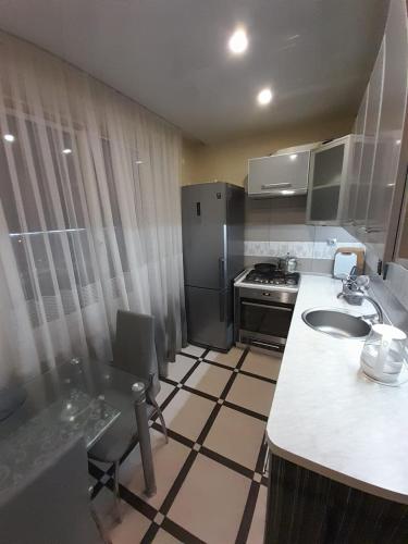 uma pequena cozinha com um lavatório e um fogão em Apartments Новые дома Масельского Хтз em Kharkov