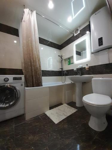 y baño con aseo, lavabo y lavadora. en Apartments Новые дома Масельского Хтз en Járkov