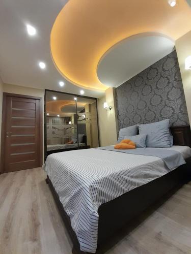 a bedroom with a large bed with a yellow ceiling at Apartments Новые дома Масельского Хтз in Kharkiv