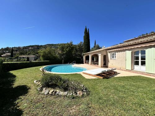une cour arrière avec une piscine et une maison dans l'établissement L'Oulivo, Villa pour 10 personnes avec piscine privée dans le Domaine de Valcros à La Londe-les-Maures, à La Londe-les-Maures