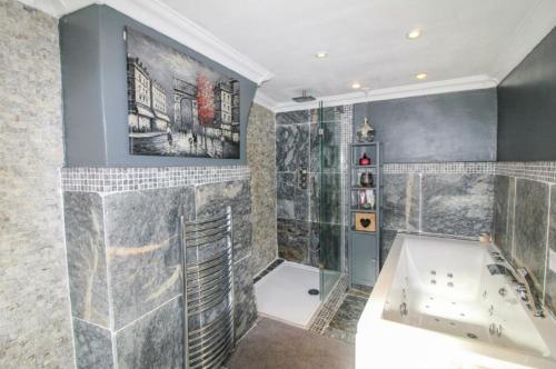 a large bathroom with a tub and a shower at Marwood Cottage in Ripon