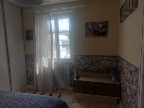 a bedroom with a bed and a window at LES ROSSIGNOLS in Saint-Martin-sur-Ocre