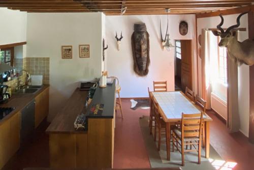 une cuisine avec une table et une salle à manger dans l'établissement Charming Normandy House with sauna, apple orchard, short walk to the beach, à Vattetot-sur-Mer