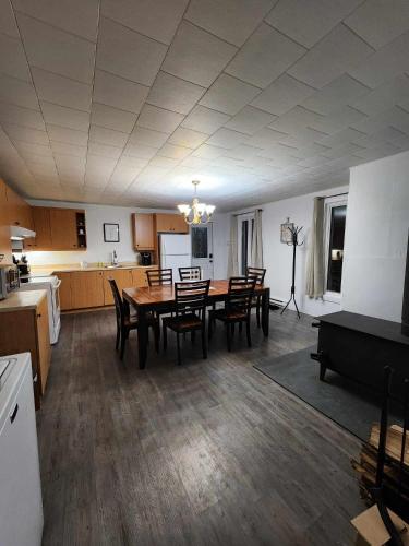 een keuken met een tafel en stoelen in een kamer bij Oasis de la Baie in Port-Daniel