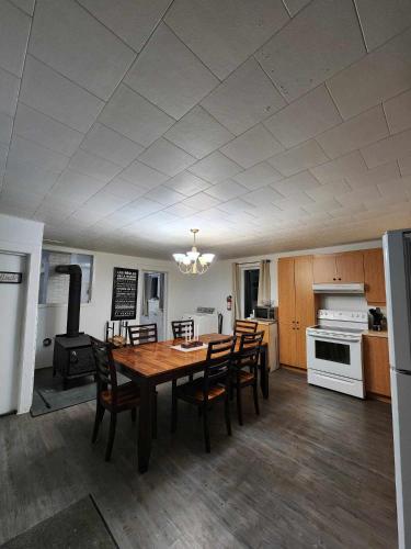 uma cozinha e sala de jantar com mesa e cadeiras em Oasis de la Baie em Port-Daniel