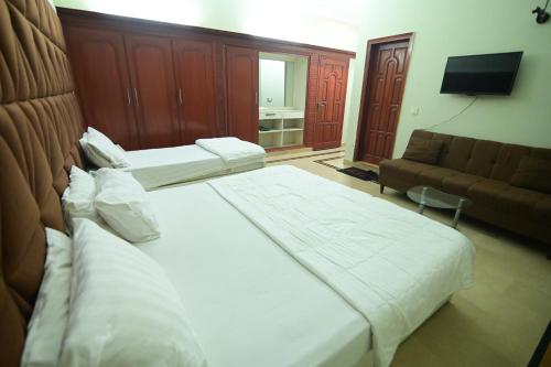 a hotel room with two beds and a couch at SEAVIEW COTTAGE in Karachi