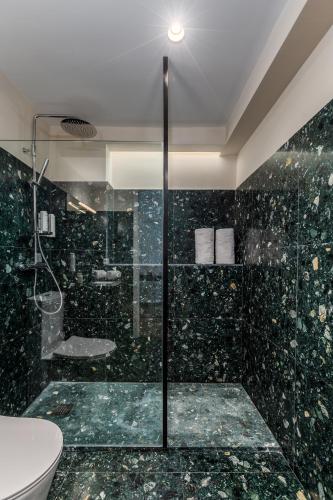 a bathroom with a glass shower and a toilet at Aspasios Bonjardim Apartments in Porto