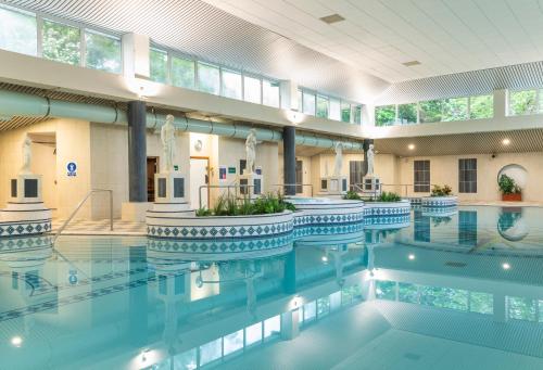 a swimming pool with blue water in a building at Grand Hotel in Malahide