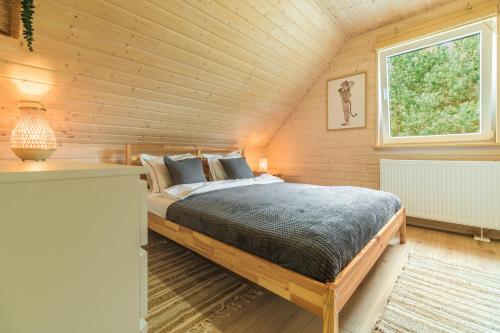 a bedroom with a bed in a wooden cabin at Dom na Mazurach nad jeziorem Isąg Pora Jeziora in Pelnik