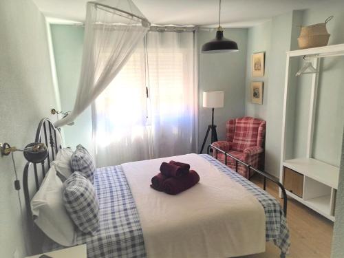 una camera da letto con un letto e un asciugamano sopra di Logrocity Puerta del Ebro Parking privado gratis a Logroño