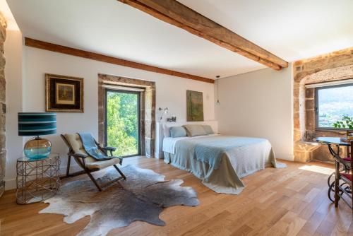 ein Schlafzimmer mit einem Bett, einem Stuhl und einem Fenster in der Unterkunft A casa dos Parladoiros in Mos