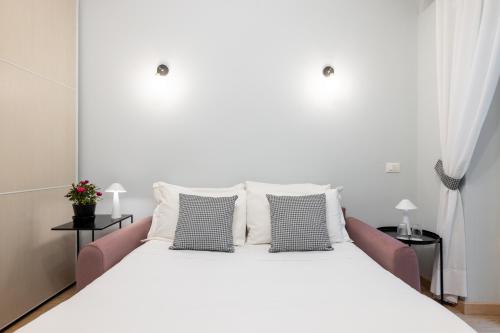 un letto bianco con tre cuscini sopra di Domus Bella Roma a Roma